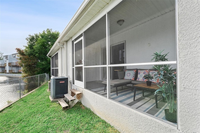 view of property exterior featuring central air condition unit, a sunroom, and stucco siding