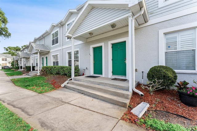 entrance to property with stucco siding and a residential view