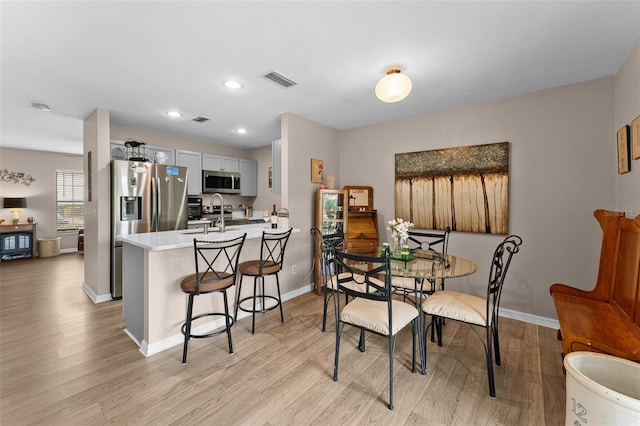 5503 67th Ave N Unit 18, Pinellas Park, FL 33781 - dining area featuring light wood finished floors, baseboards, and recessed lighting