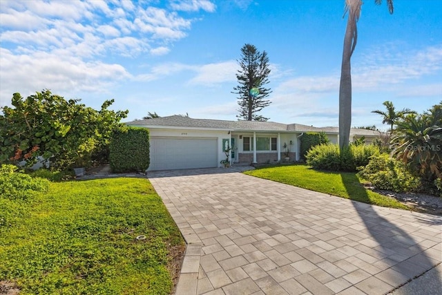 2540 S Shore Dr SE, Saint Petersburg, FL 33705 - ranch-style house with a garage, stucco siding, decorative driveway, and a front yard