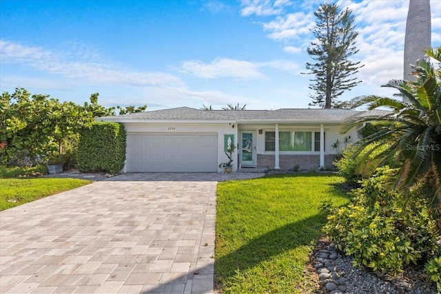 2540 S Shore Dr SE, Saint Petersburg, FL 33705 - ranch-style house featuring a garage, a front lawn, decorative driveway, and stucco siding