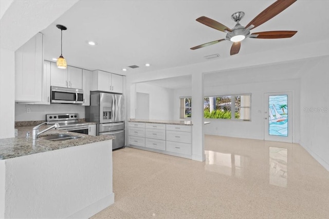 2540 S Shore Dr SE, Saint Petersburg, FL 33705 - kitchen with light stone counters, appliances with stainless steel finishes, a sink, visible vents, and a ceiling fan