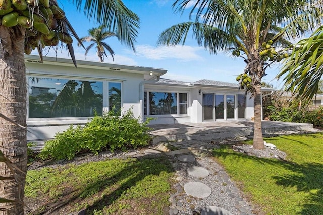 2540 S Shore Dr SE, Saint Petersburg, FL 33705 - rear view of house featuring a patio, stucco siding, and a yard