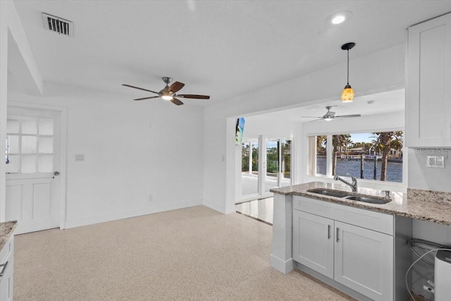 2540 S Shore Dr SE, Saint Petersburg, FL 33705 - kitchen with a sink, ceiling fan, a water view, visible vents, and light stone counters