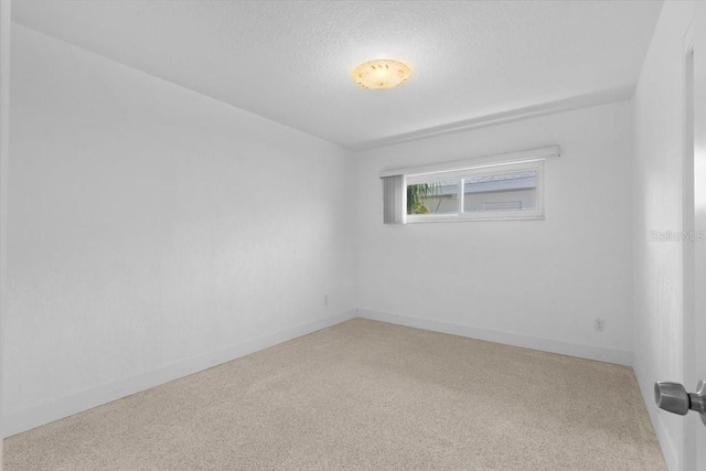 2540 S Shore Dr SE, Saint Petersburg, FL 33705 - empty room with baseboards, a textured ceiling, and carpet floors