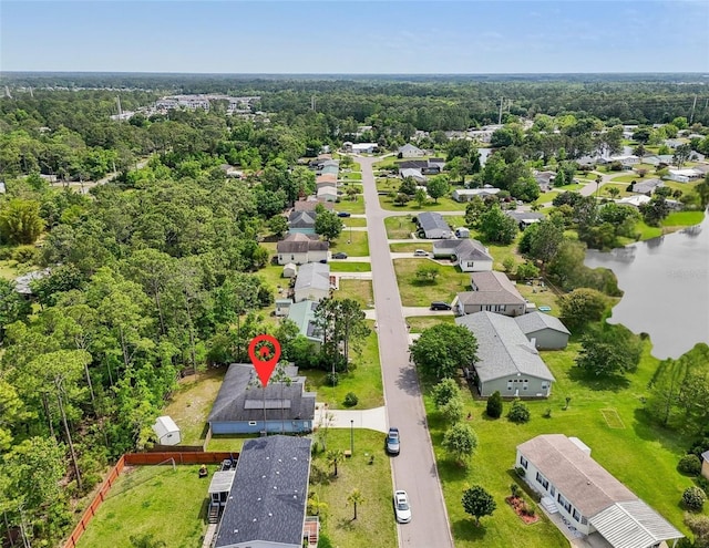 aerial view of residential area with a nearby body of water and a forest