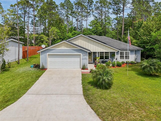 2720 N Screech Owl Ave, Saint Augustine, FL 32084 - ranch-style home with concrete driveway, an attached garage, board and batten siding, roof with shingles, and view of wooded area