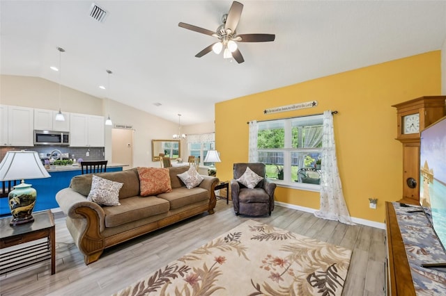 2720 N Screech Owl Ave, Saint Augustine, FL 32084 - living room with lofted ceiling, a ceiling fan, light wood finished floors, and a chandelier