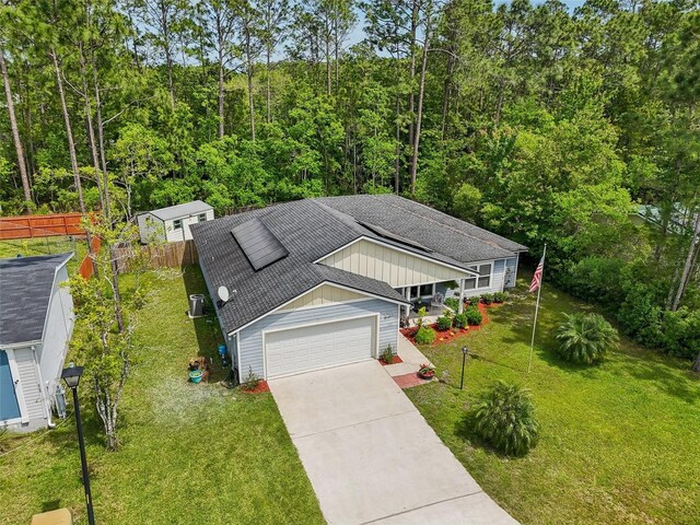 2720 N Screech Owl Ave, Saint Augustine, FL 32084 - view of front of property with a shingled roof, driveway, board and batten siding, an attached garage, and a forest view