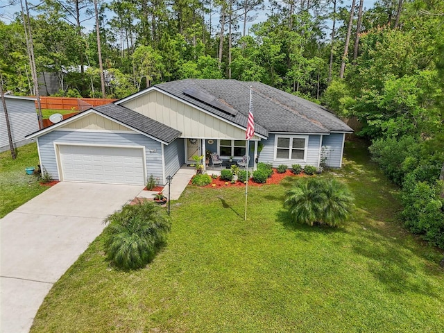 2720 N Screech Owl Ave, Saint Augustine, FL 32084 - ranch-style house featuring a garage, roof with shingles, roof mounted solar panels, and a front lawn