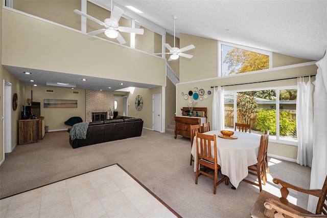 508 N Mayo St, Crystal Beach, FL 34681 - carpeted dining room featuring ceiling fan, a textured ceiling, a fireplace, high vaulted ceiling, and baseboards