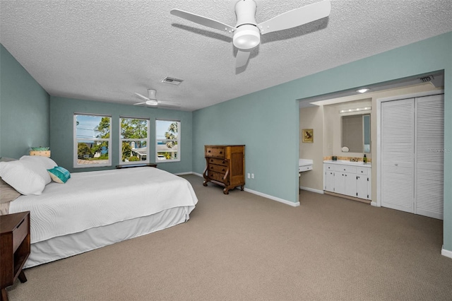 508 N Mayo St, Crystal Beach, FL 34681 - carpeted bedroom with baseboards, ensuite bathroom, a textured ceiling, and visible vents