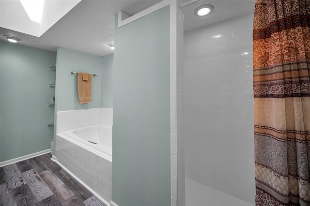 508 N Mayo St, Crystal Beach, FL 34681 - bathroom with tiled shower, baseboards, a garden tub, and wood finished floors