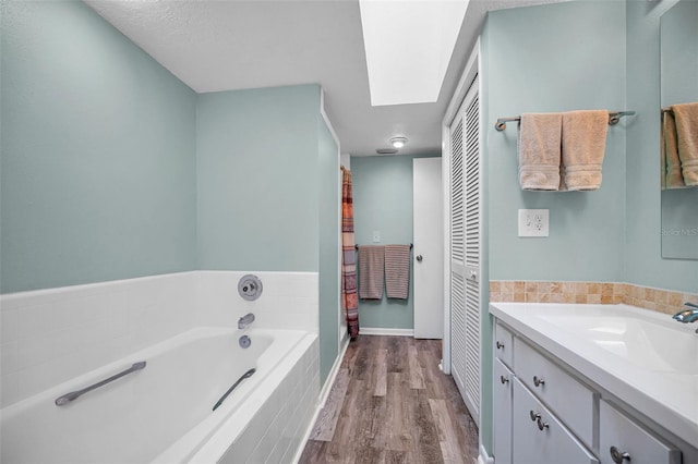 508 N Mayo St, Crystal Beach, FL 34681 - bathroom with a garden tub, wood finished floors, vanity, baseboards, and a closet