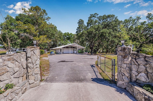 view of street with driveway, a gated entry, and a gate