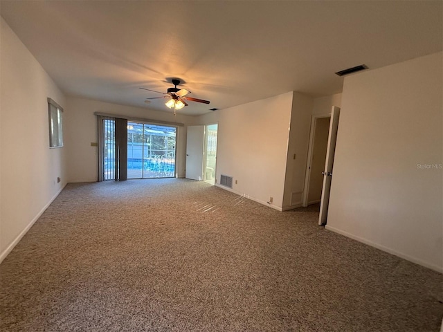empty room with carpet, visible vents, and a ceiling fan