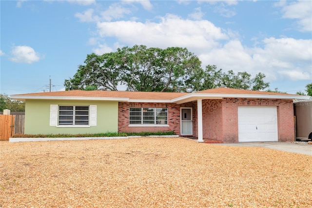 ranch-style house featuring a garage, brick siding, fence, and concrete driveway