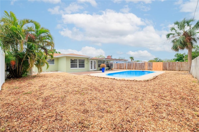 view of swimming pool with a fenced in pool, a fenced backyard, french doors, and a patio