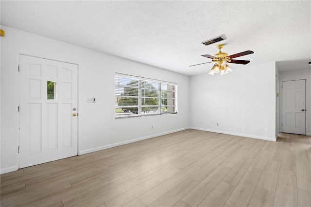 unfurnished living room featuring visible vents, a ceiling fan, light wood-style flooring, and baseboards