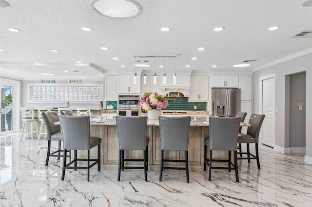 kitchen featuring visible vents, ornamental molding, white cabinetry, appliances with stainless steel finishes, and backsplash