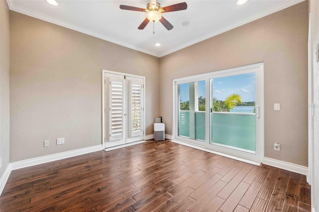 spare room with baseboards, ornamental molding, ceiling fan, and wood finished floors
