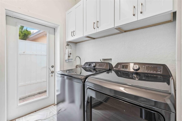 clothes washing area featuring cabinet space and washing machine and dryer
