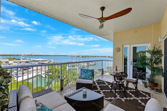 balcony featuring outdoor lounge area, a ceiling fan, and a water view