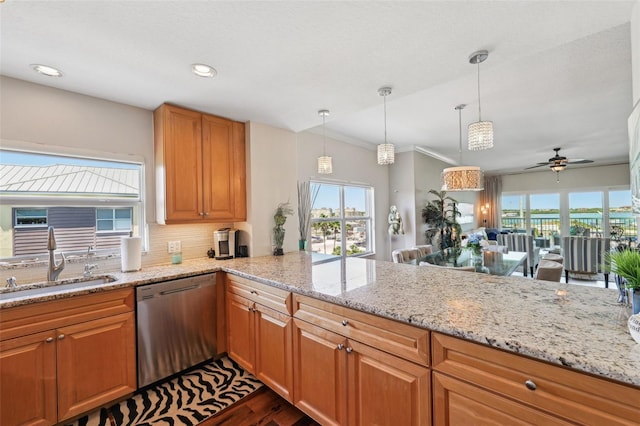 kitchen featuring a sink, a ceiling fan, light stone counters, stainless steel dishwasher, and dark wood finished floors