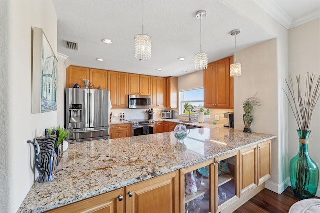 kitchen with appliances with stainless steel finishes, light stone counters, a peninsula, and visible vents