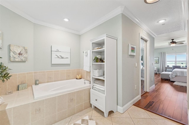 ensuite bathroom featuring tile patterned floors, ceiling fan, ensuite bathroom, a garden tub, and crown molding