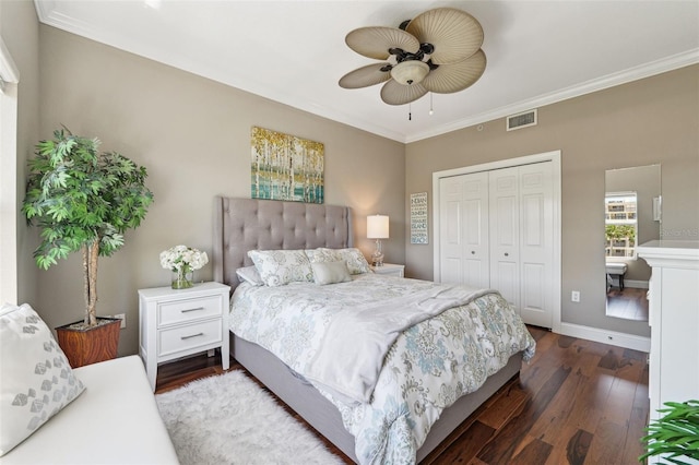 bedroom featuring crown molding, a closet, visible vents, and wood finished floors