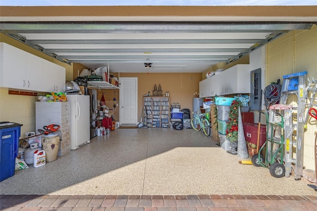 20605 Long Pond Rd, North Fort Myers, FL 33917 - garage with freestanding refrigerator, electric panel, concrete block wall, and a garage door opener
