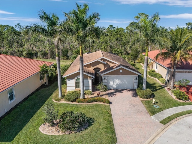 20605 Long Pond Rd, North Fort Myers, FL 33917 - view of front of house featuring a garage, decorative driveway, a front yard, and stucco siding
