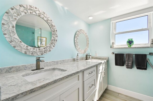5200 Brittany Dr S Unit 1502, Saint Petersburg, FL 33715 - full bathroom featuring double vanity, baseboards, a sink, and wood finished floors
