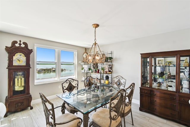 5200 Brittany Dr S Unit 1502, Saint Petersburg, FL 33715 - dining space with a water view, a notable chandelier, baseboards, and light wood-style flooring