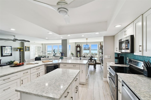 5200 Brittany Dr S Unit 1502, Saint Petersburg, FL 33715 - kitchen featuring ceiling fan, recessed lighting, a kitchen island, appliances with stainless steel finishes, and beverage cooler