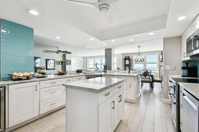 5200 Brittany Dr S Unit 1502, Saint Petersburg, FL 33715 - kitchen with stainless steel appliances, recessed lighting, a peninsula, and ceiling fan with notable chandelier