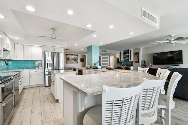5200 Brittany Dr S Unit 1502, Saint Petersburg, FL 33715 - kitchen with visible vents, a ceiling fan, a spacious island, and stainless steel appliances