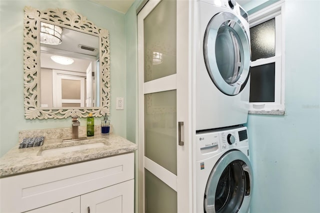 5200 Brittany Dr S Unit 1502, Saint Petersburg, FL 33715 - washroom featuring a sink, visible vents, stacked washing maching and dryer, and laundry area