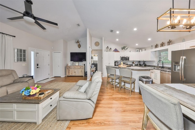 8805 Van Fleet Rd, Riverview, FL 33578 - living room with recessed lighting, visible vents, lofted ceiling, light wood finished floors, and ceiling fan with notable chandelier