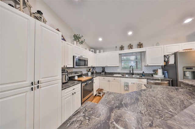 8805 Van Fleet Rd, Riverview, FL 33578 - kitchen with tasteful backsplash, appliances with stainless steel finishes, white cabinetry, lofted ceiling, and a sink