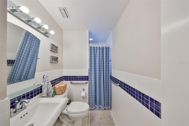 8805 Van Fleet Rd, Riverview, FL 33578 - full bathroom featuring visible vents, toilet, a sink, tile walls, and tile patterned floors