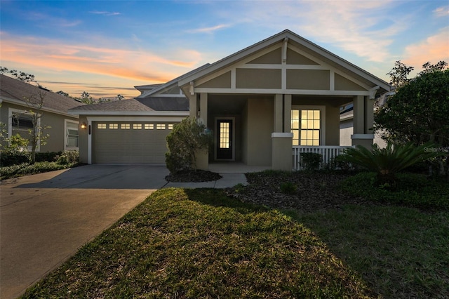 view of front of property featuring an attached garage, concrete driveway, stucco siding, and a porch