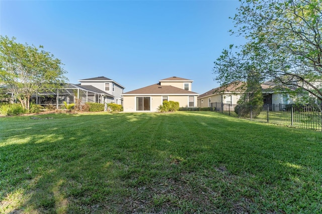 view of yard with a fenced backyard and glass enclosure