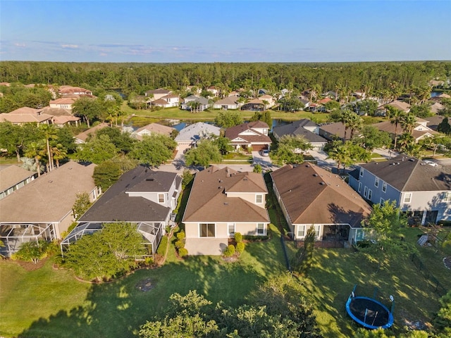 drone / aerial view featuring a view of trees and a residential view