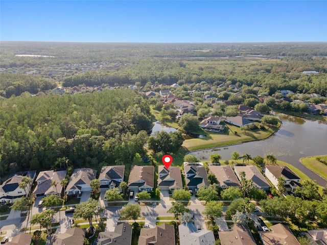 birds eye view of property featuring a water view, a residential view, and a wooded view
