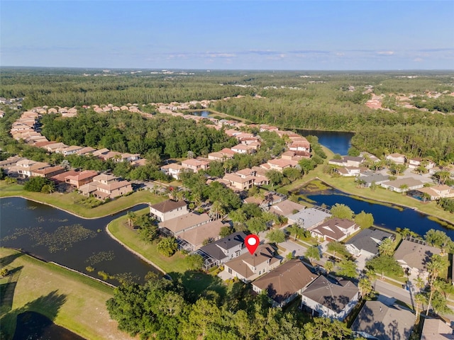 bird's eye view featuring a wooded view, a residential view, and a water view