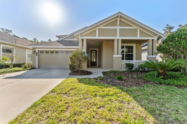 craftsman-style house featuring concrete driveway, stucco siding, a front yard, a porch, and a garage