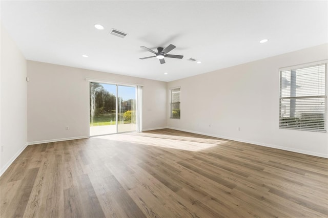 unfurnished room featuring light wood-style flooring, baseboards, a ceiling fan, and visible vents