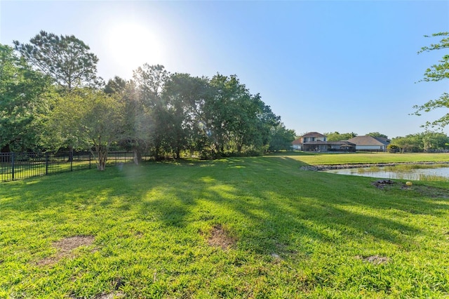 view of yard featuring fence and a water view